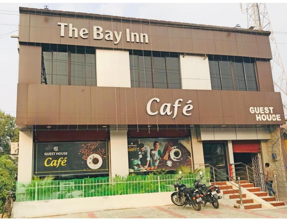 ein Gebäude mit Motorrädern, die außerhalb eines Cafés geparkt sind in der Unterkunft Hotel The Bay Inn, Konark in Pānchagān