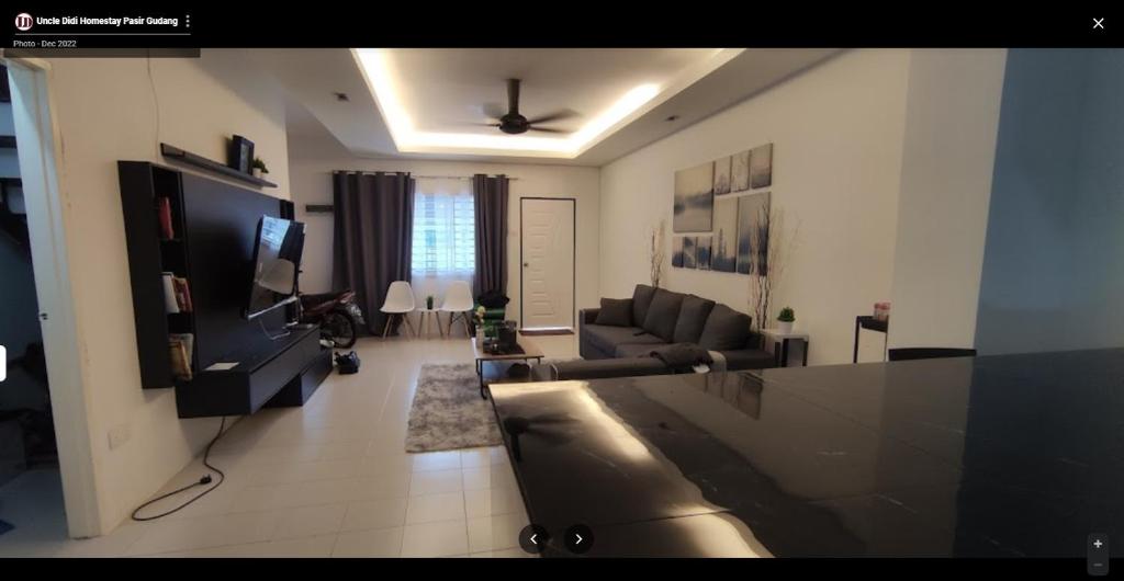 ein Wohnzimmer mit einem Sofa und einem TV in der Unterkunft Uncle Didi Guest House Pasir Gudang in Pasir Gudang
