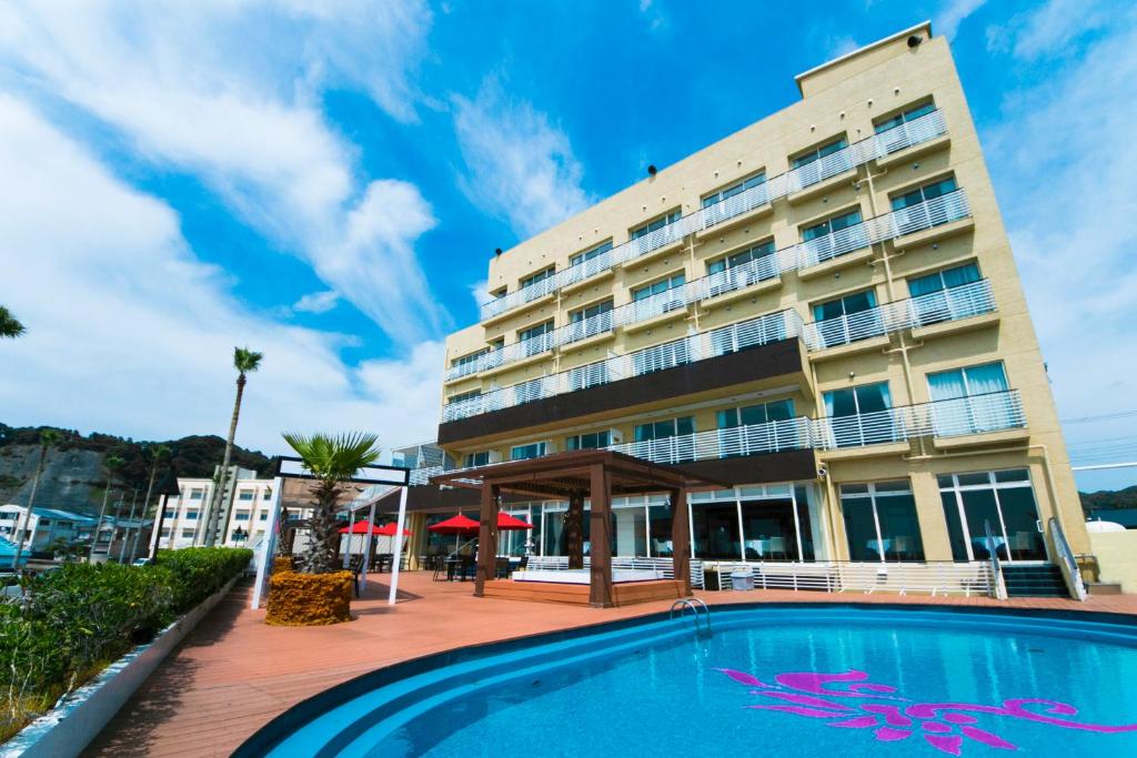 un hotel con piscina frente a un edificio en Sayan Terrace Hotel & Resort, en Onjuku