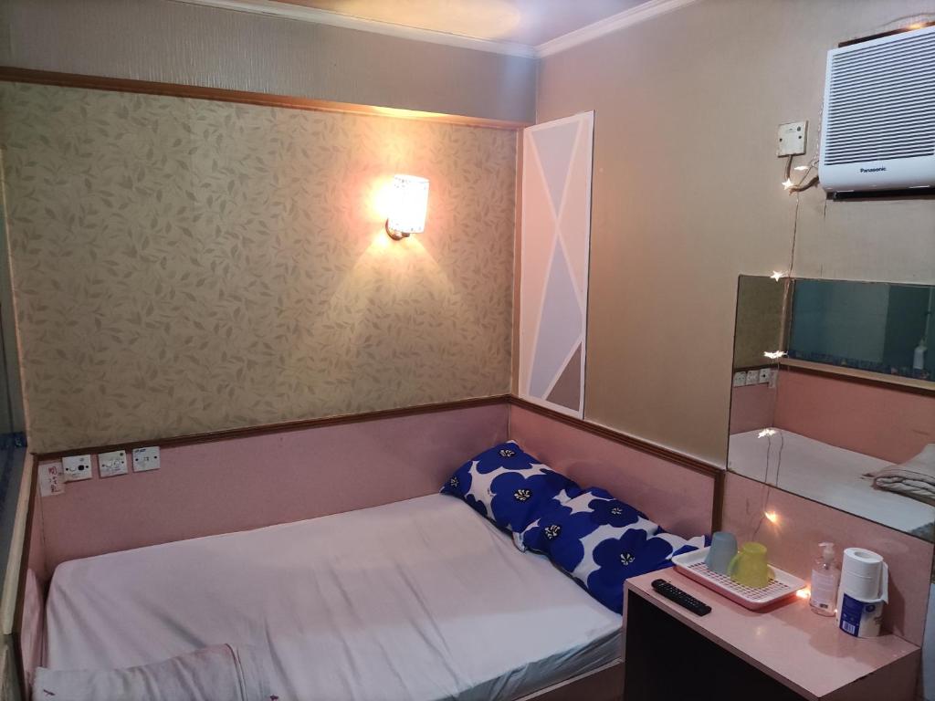 a small room with a small bed and a desk at 嘉湖旅館 in Hong Kong