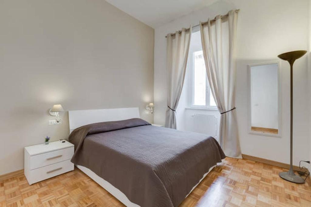 1 dormitorio con 1 cama, vestidor y ventana en Vantaggio Suites en Roma