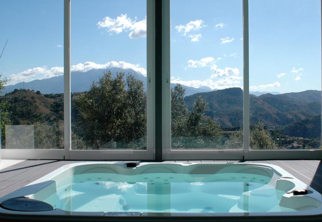 bañera en una habitación con vistas a las montañas en JINGTU Wellness & Spa B&B, en Comares