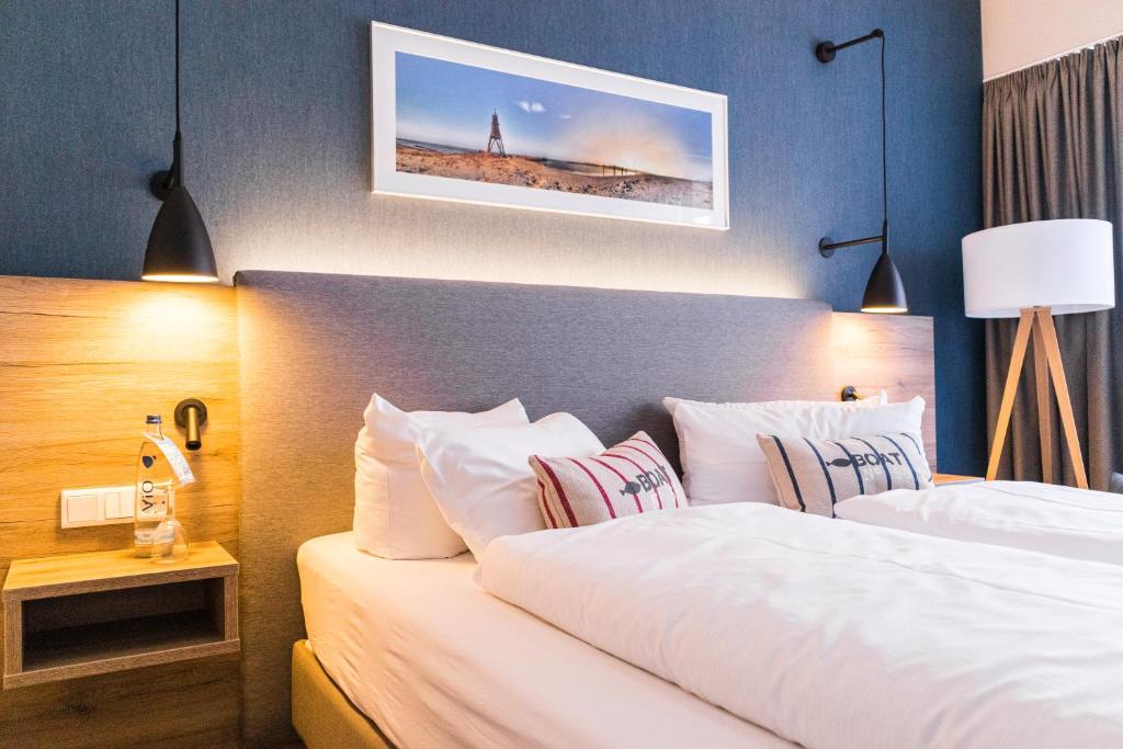 ein Hotelzimmer mit 2 Betten und weißen Kissen in der Unterkunft Hotel Wehrburg in Cuxhaven