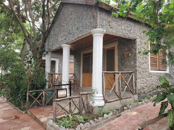 a small stone house with a porch and a door at Mwanza lake view FARM Eco LODGE in Sengerema