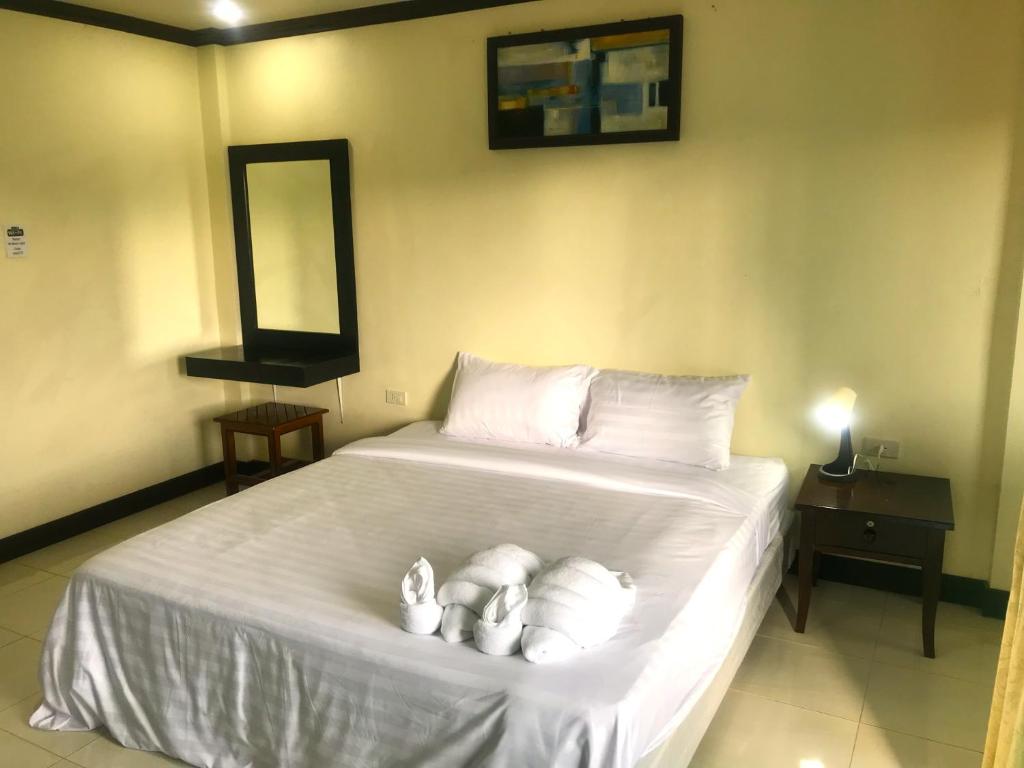 ein Schlafzimmer mit einem Bett mit weißen Handtüchern darauf in der Unterkunft Parisia House in Khao Lak
