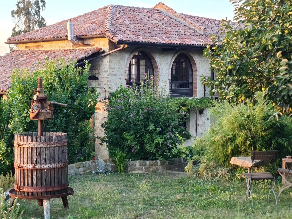 an old house with a barrel in the yard at Cascina IL SOGNO in Cossano Belbo