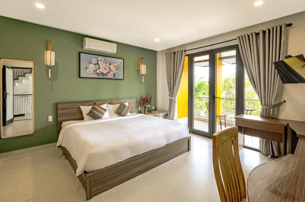 a bedroom with a large bed and a balcony at HOIANIAN CENTRAL VILLA in Hoi An