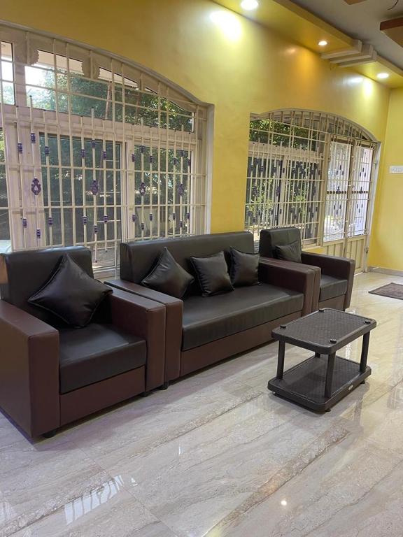 sala de estar con sofá marrón y mesa en RIVER VIEW HOME STAY SERVICE APARTMENT en Madurai