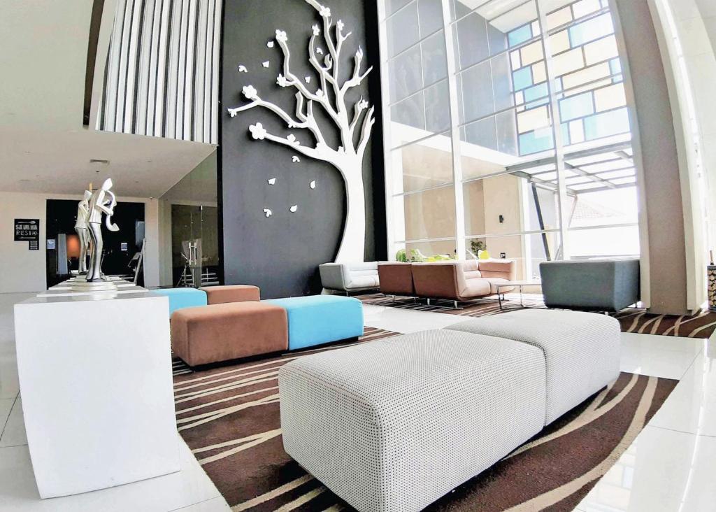 a lobby with a tree mural on the wall at Bromo Park Hotel Probolinggo in Probolinggo