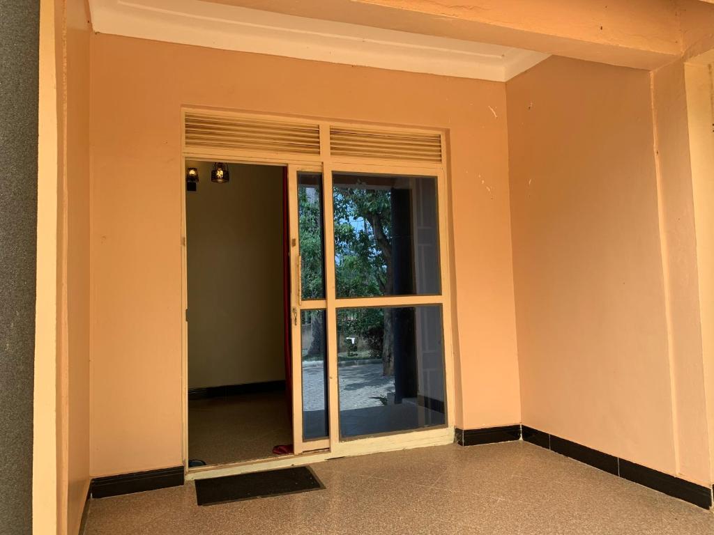 une pièce vide avec une porte coulissante en verre dans l'établissement Green Haven, à Mbale