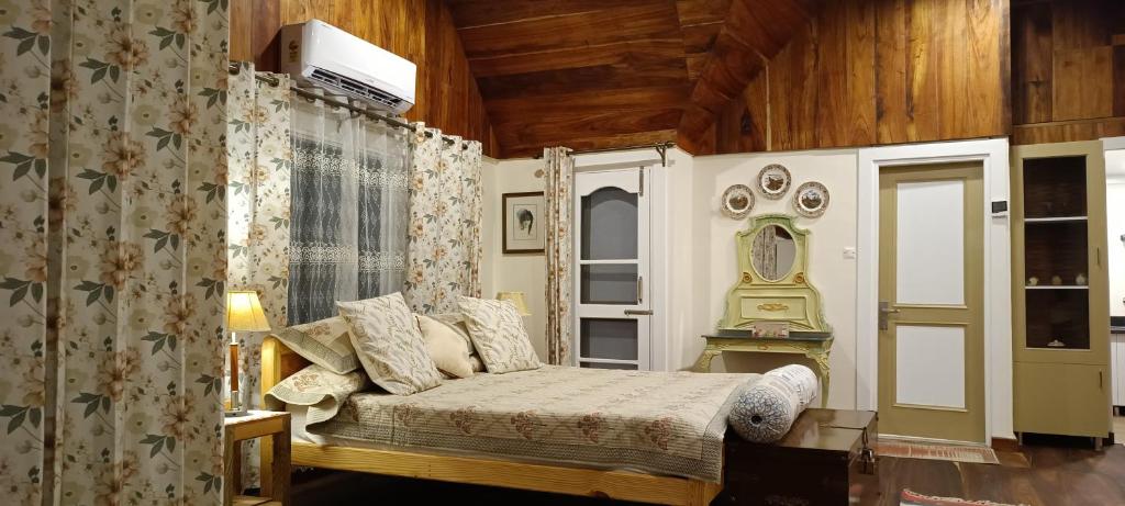 a bedroom with a bed and a window at Chinarchalet in Pālampur