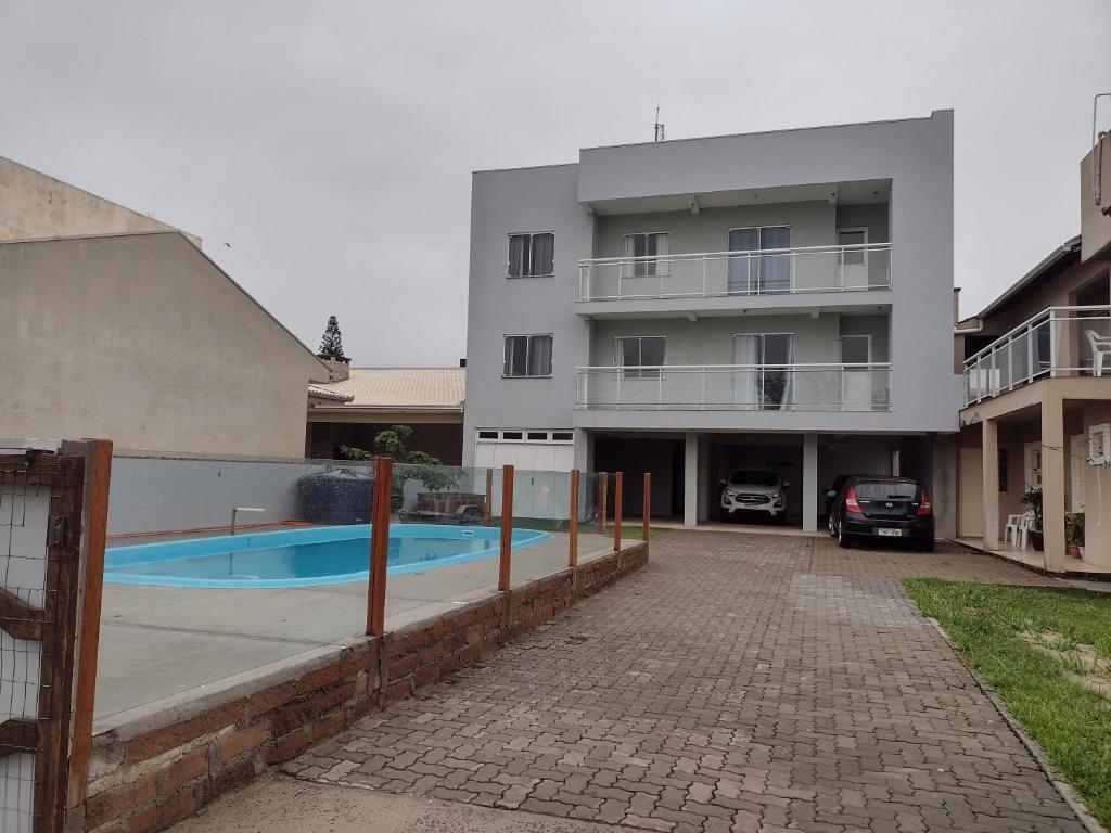 un edificio de apartamentos con piscina frente a él en Férias Praia Real 100m do mar, en Torres