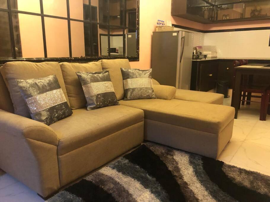a brown couch with pillows on it in a living room at Luzville Residences - C8 in Naic
