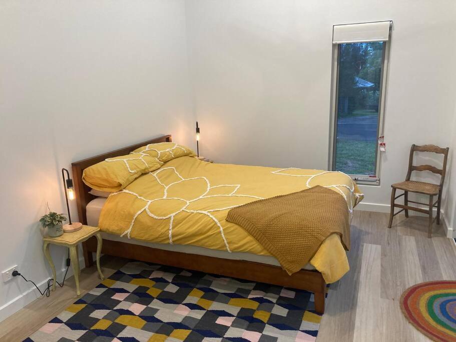 a bedroom with a bed and a chair and a window at Blue Heart Studio Apartment in Willunga
