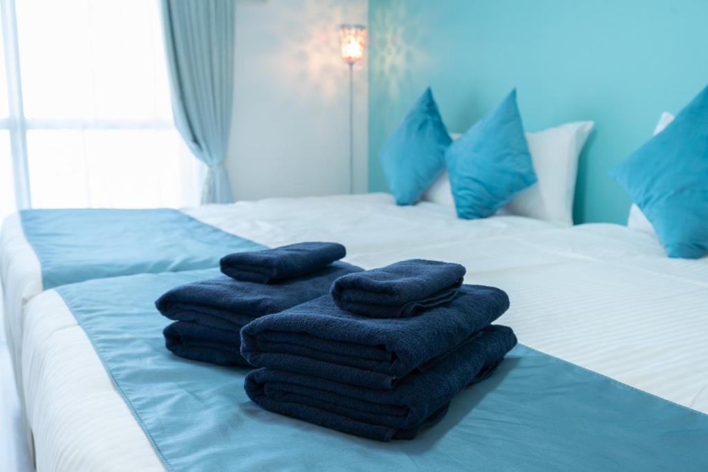 una pila de toallas sentadas encima de una cama en Fuchsia - Vacation STAY 08005v en Nagoya