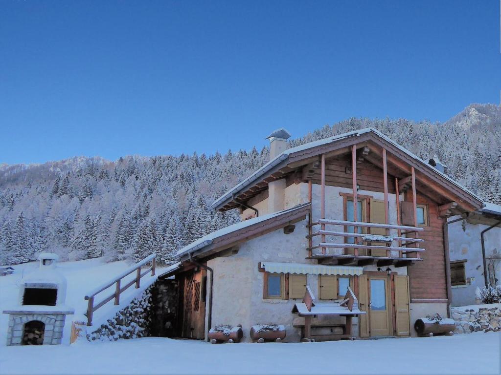 a log cabin in the snow with snow covered trees at Delightful hut with spectacular views of the Pale di San Martino in Tonadico