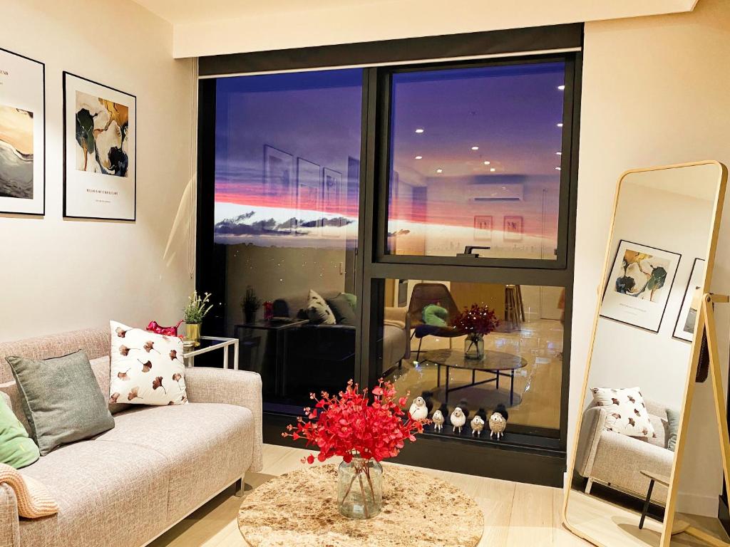 Skyone Lux 2Bed room Aprt in BoxHill with car park في بوكسهل: غرفة معيشة مع أريكة ونافذة كبيرة