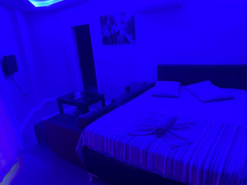 - une chambre avec un lit dans une pièce bleue dans l'établissement İmperyum park vilları, à Çiftlikköy