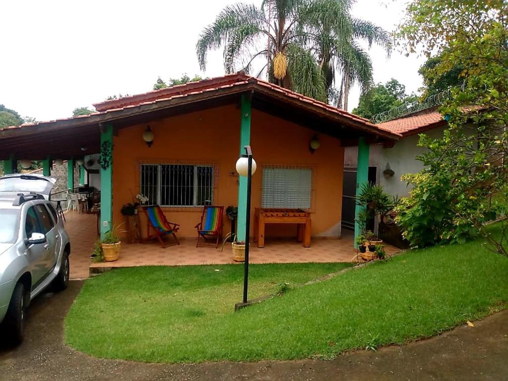 une maison avec une voiture garée devant elle dans l'établissement Chácara de Temporada - Mairiporã, à Mairiporã