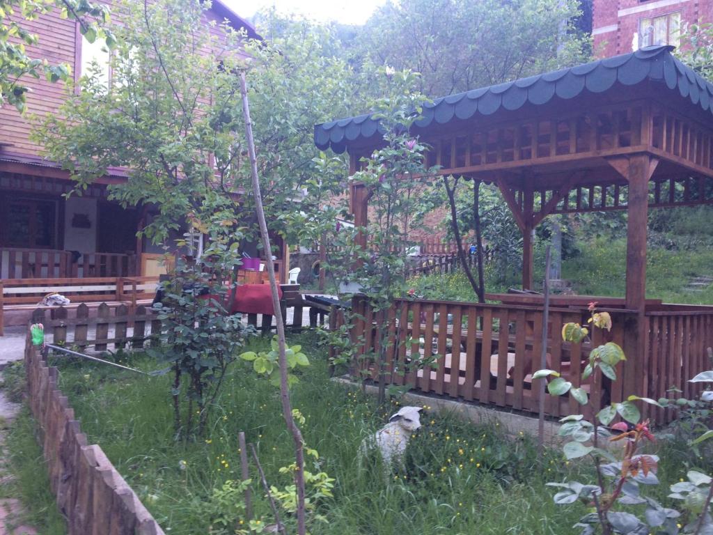 a garden with a wooden gazebo in a yard at YEŞİLDERE VİLLA in Akcaabat