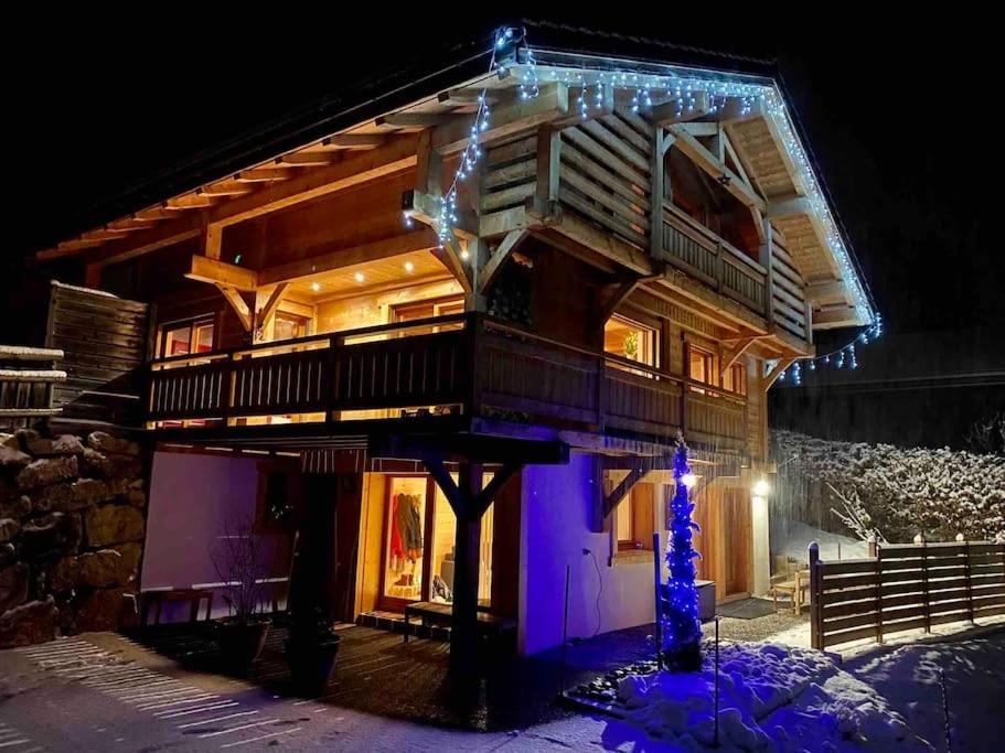 una casa de madera con luces de Navidad en ella en Androsace Appartement dans Chalet bois avec Jacuzzi privatif Terrasse et Vue Montagne, en Les Villards-sur-Thônes