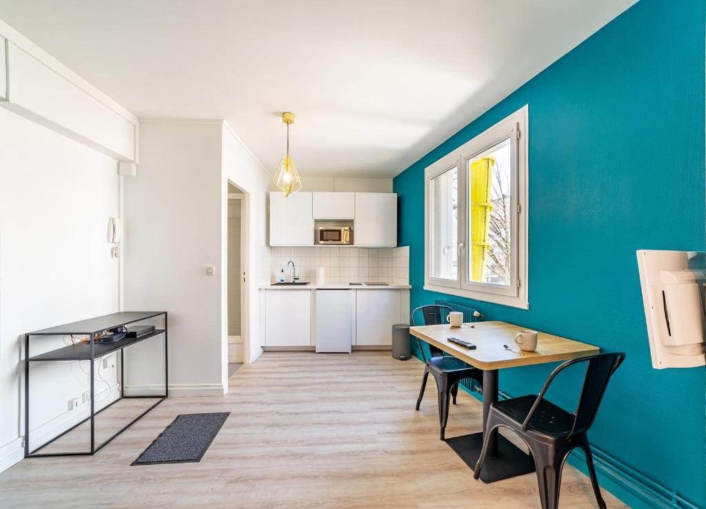 cocina con mesa y pared azul en Centre ville Foirail APPART EVASION - Studio N°1, en Pau