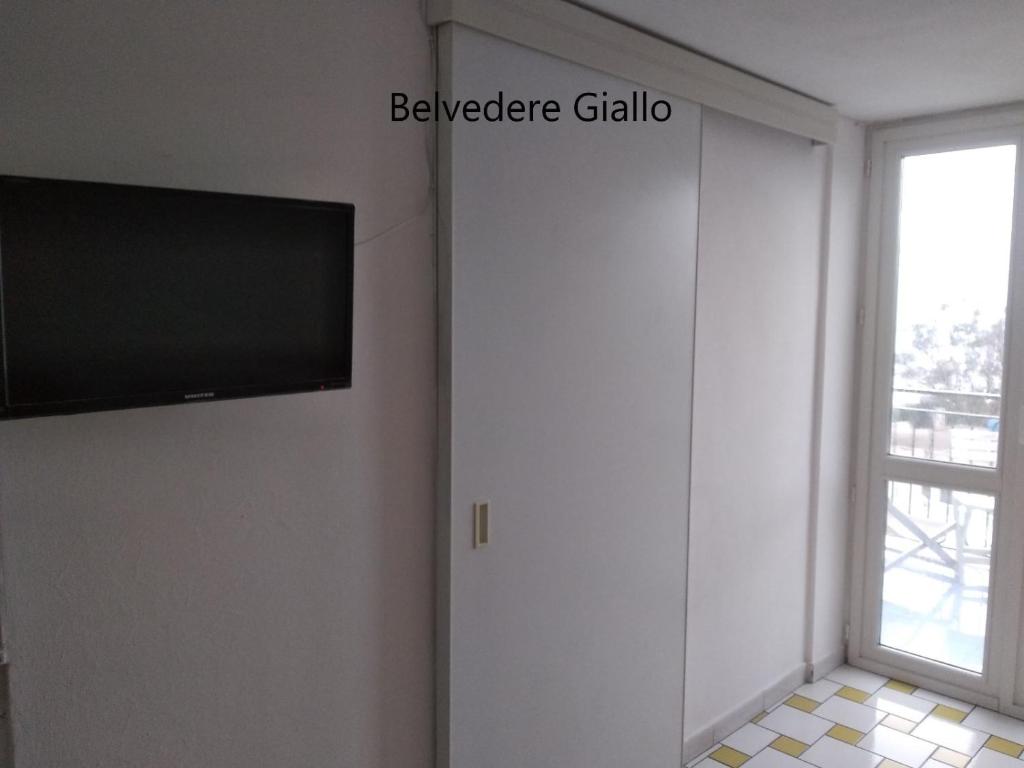 een woonkamer met een flatscreen-tv en een raam bij Ponzamania Appartamenti ,,Belvedere'' Ponza in Ponza