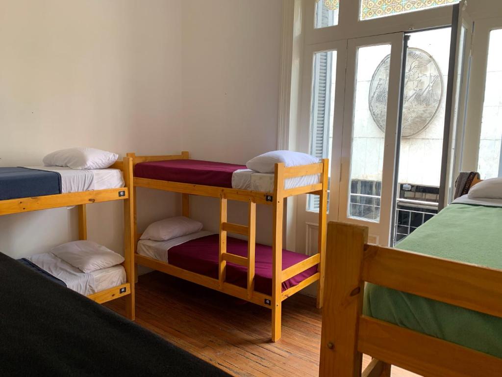 a room with three bunk beds and a window at MiBAQ Hostel in Buenos Aires