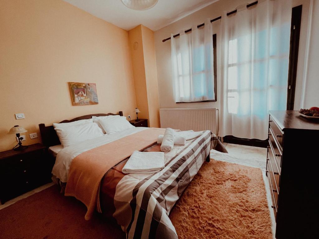 a bedroom with a large bed and a window at Muses Apartments in Pisoderi