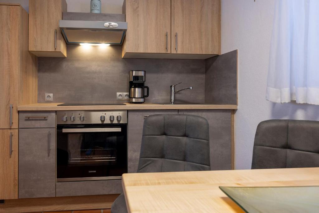 a kitchen with an oven and a table with chairs at Gästehaus Strauss in Seefeld in Tirol