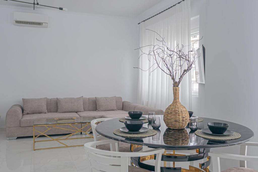 een woonkamer met een tafel met een vaas erop bij Arcade apartments in Volos