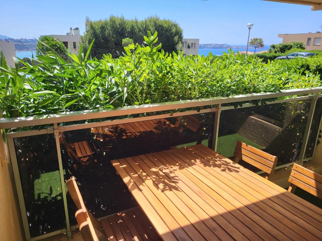 eine Holzbank auf dem Balkon in der Unterkunft T2 plage de sable à 300m+ parking gratuit in Bandol