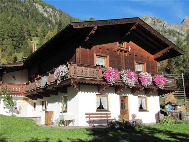 ein Gebäude mit einem Balkon mit Blumen darauf in der Unterkunft Ferienhaus Reinhard Steiner in Hinterbichl