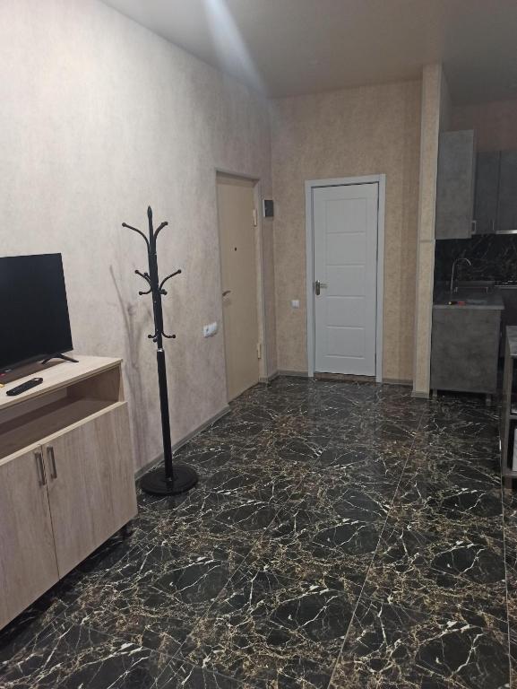 ein Wohnzimmer mit einem Fußboden mit schwarzem Marmor in der Unterkunft Nodar Bokhua st.10 in Tbilisi City