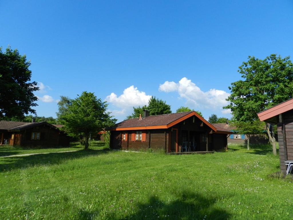 una casa con un campo verde delante de ella en Ferienhaus Bruckner Hayingen Lauterdörfle en Hayingen