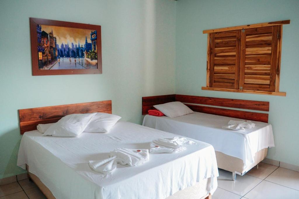 諾布里斯的住宿－Pousada do Nondas，一间卧室设有两张床和窗户。