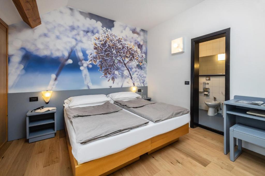 a small bedroom with a bed and a bathroom at Pippo Hotel in Terzolas