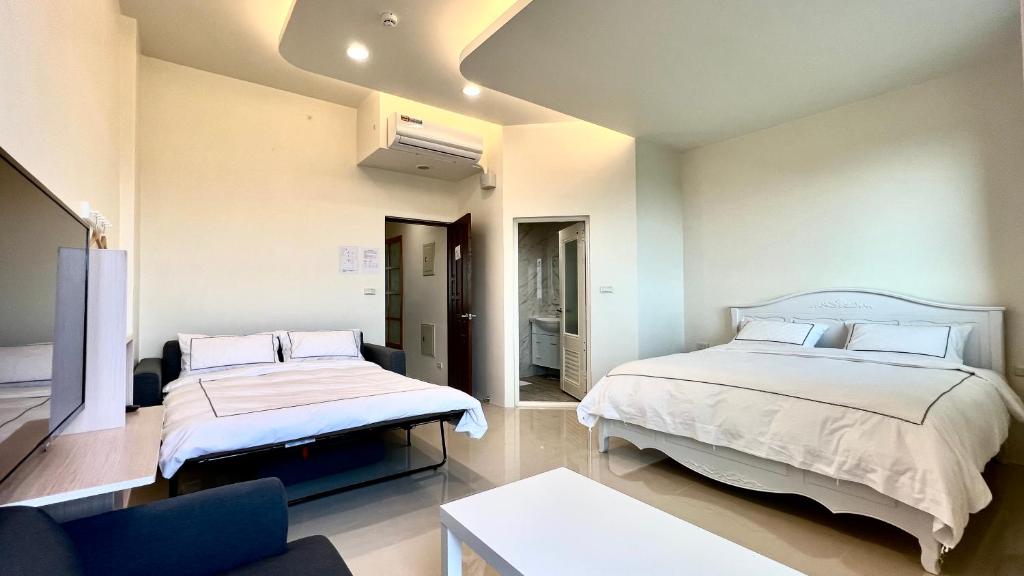 Habitación con 2 camas y sofá. en 莫民宿 MO Homestay en Yuanshan