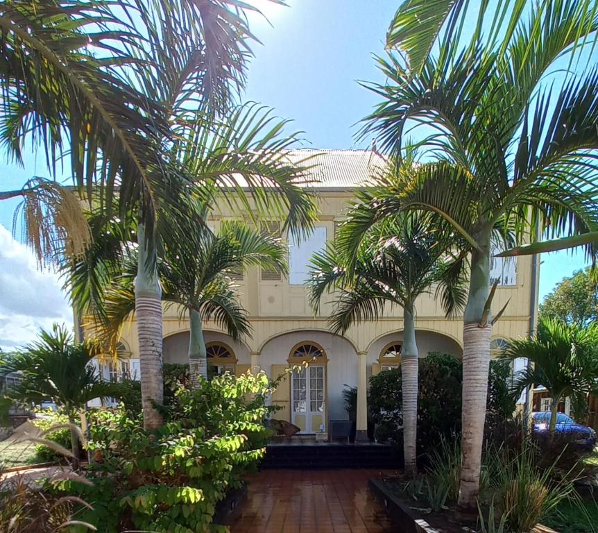 un edificio con palmeras delante en O Privilège Villa d'exception en Centre-ville de St-Pierre en San Pedro