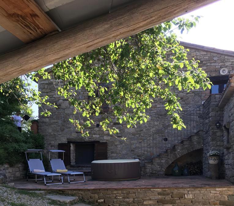 Monte Benedetto的住宿－La Busca Country House，石壁炉前的两把椅子和一张桌子