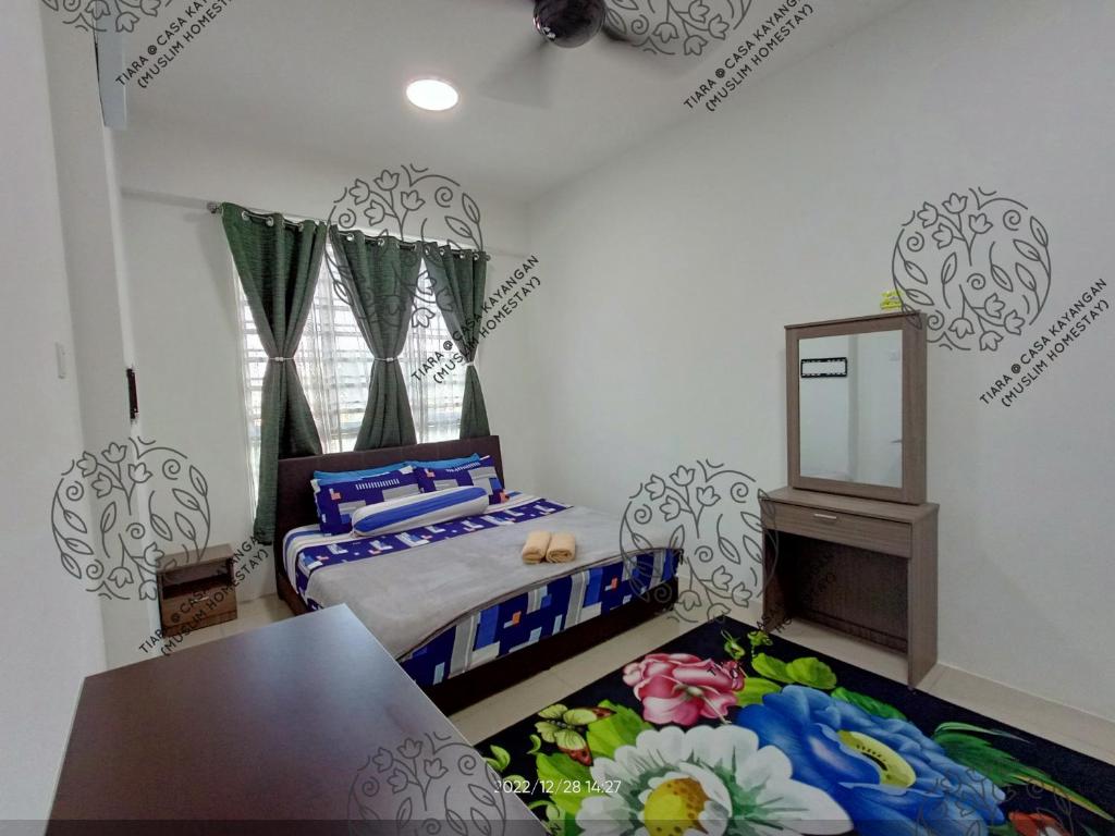 a bedroom with two beds and a table and a mirror at TIARA @ CASA KAYANGAN (MUSLIM HOMESTAY) in Ipoh