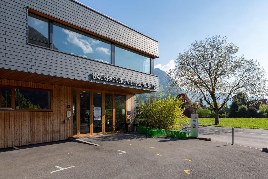 a building with a parking lot in front of it at Backpackers Villa Sonnenhof - Hostel Interlaken in Interlaken