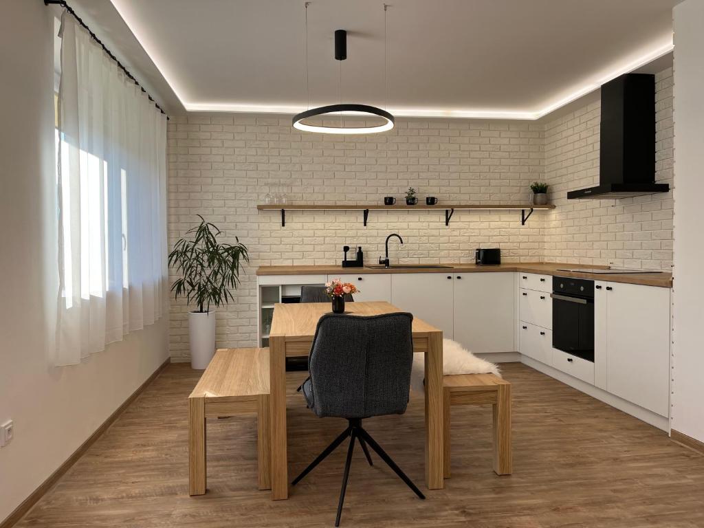 eine Küche mit einem Holztisch und einem Esszimmer in der Unterkunft Prázdninový dům Na Rajčurně in Velké Bílovice