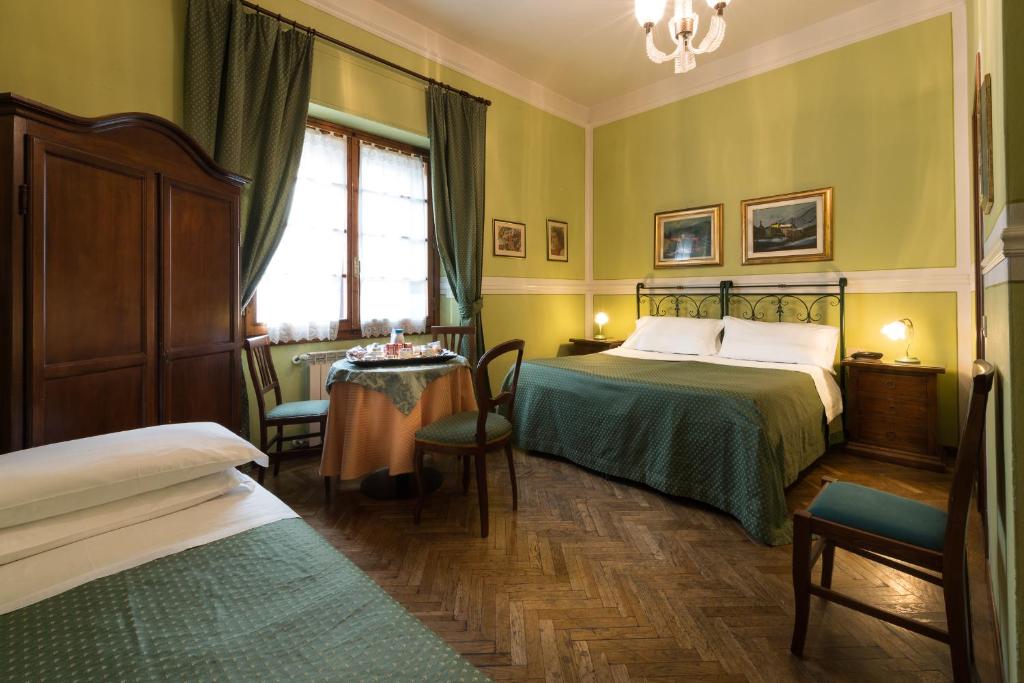 una camera d'albergo con due letti e un tavolo di B&B Old Florence Inn a Firenze