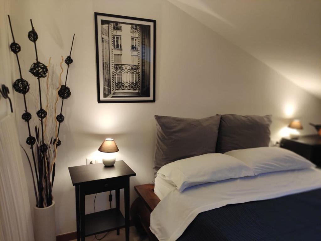 1 dormitorio con 1 cama y 1 mesa con una foto en la pared en La Casa Nel Gelso, en Bellaria-Igea Marina