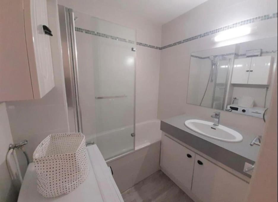 a white bathroom with a sink and a shower at Hossegor city in Soorts-Hossegor