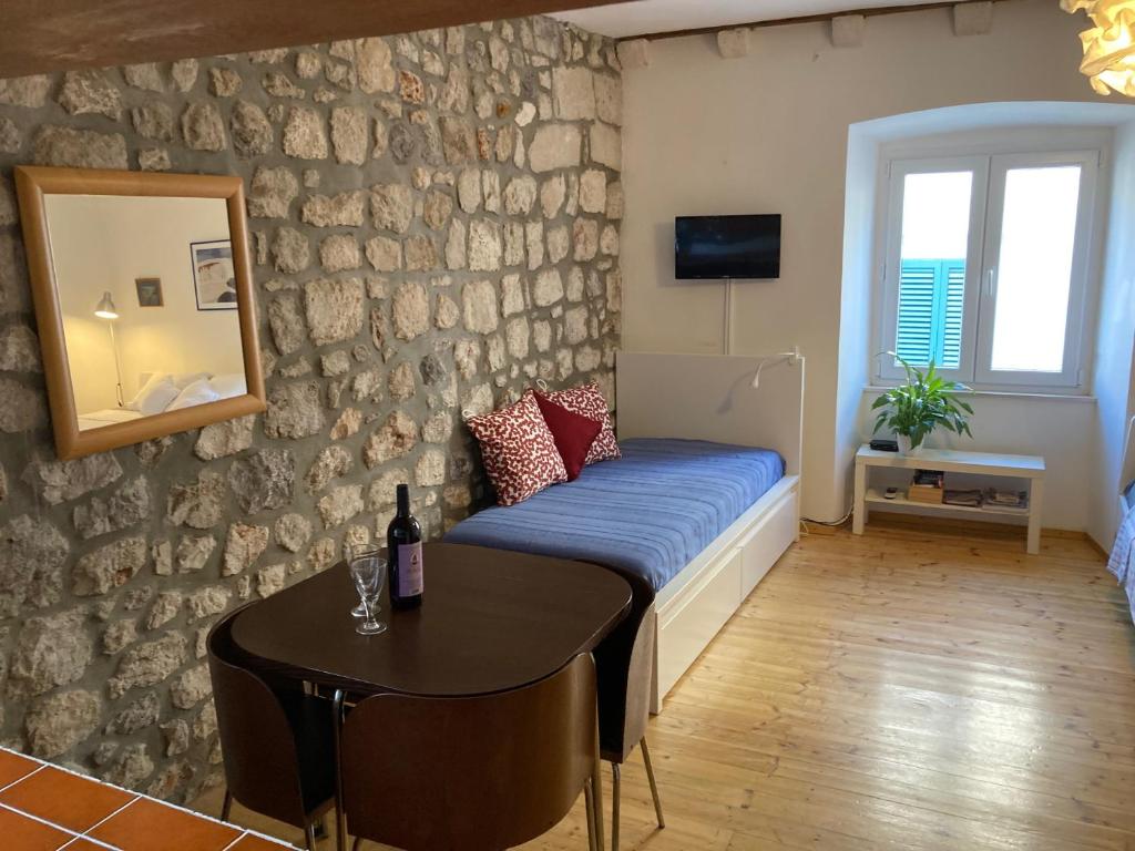 Habitación con cama, mesa y espejo. en Apartment Naval en Dubrovnik