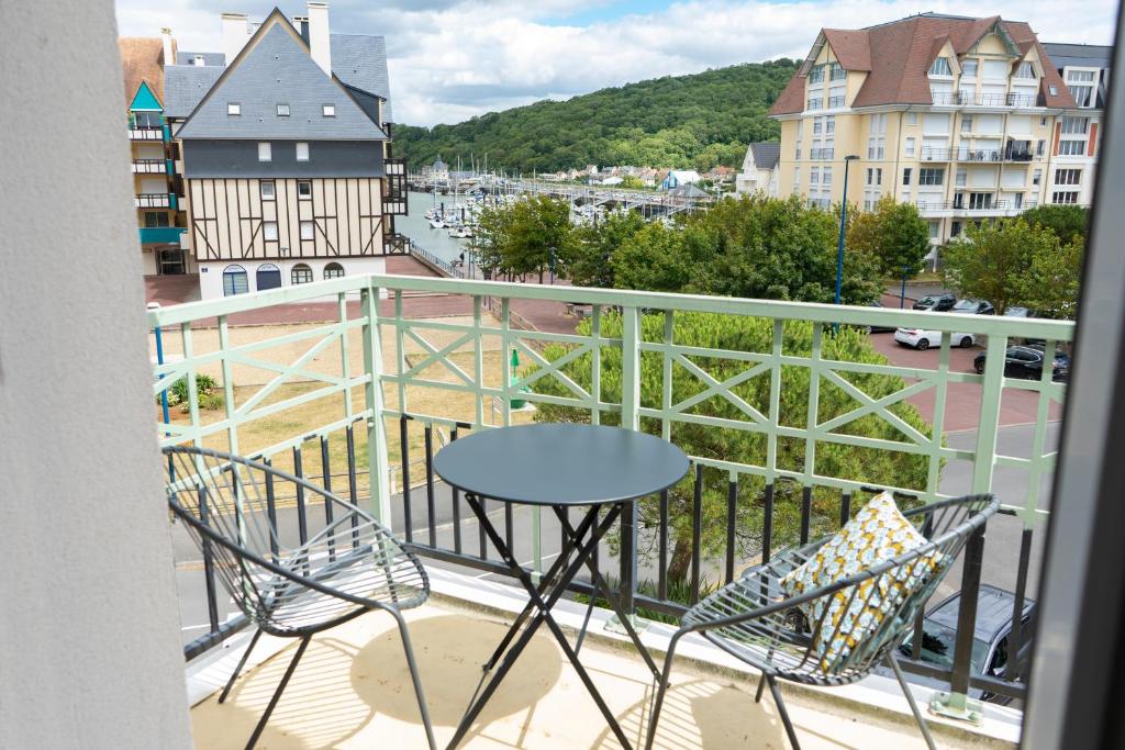 uma varanda com mesa e cadeiras e vista para a cidade em 2 pièces Port Cabourg - 2 à 4 personnes - 34 m2 - Balcon - Vue Port - Nouveau sur Booking ! em Dives-sur-Mer