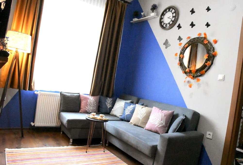 sala de estar con sofá y reloj en la pared en TAKSİM PERA House, en Estambul