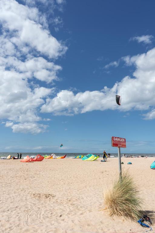 a sign on a beach with people flying kites at 2 pièces Port Cabourg - 2 à 4 personnes - 34 m2 - Balcon - Vue Port - Nouveau sur Booking ! in Dives-sur-Mer